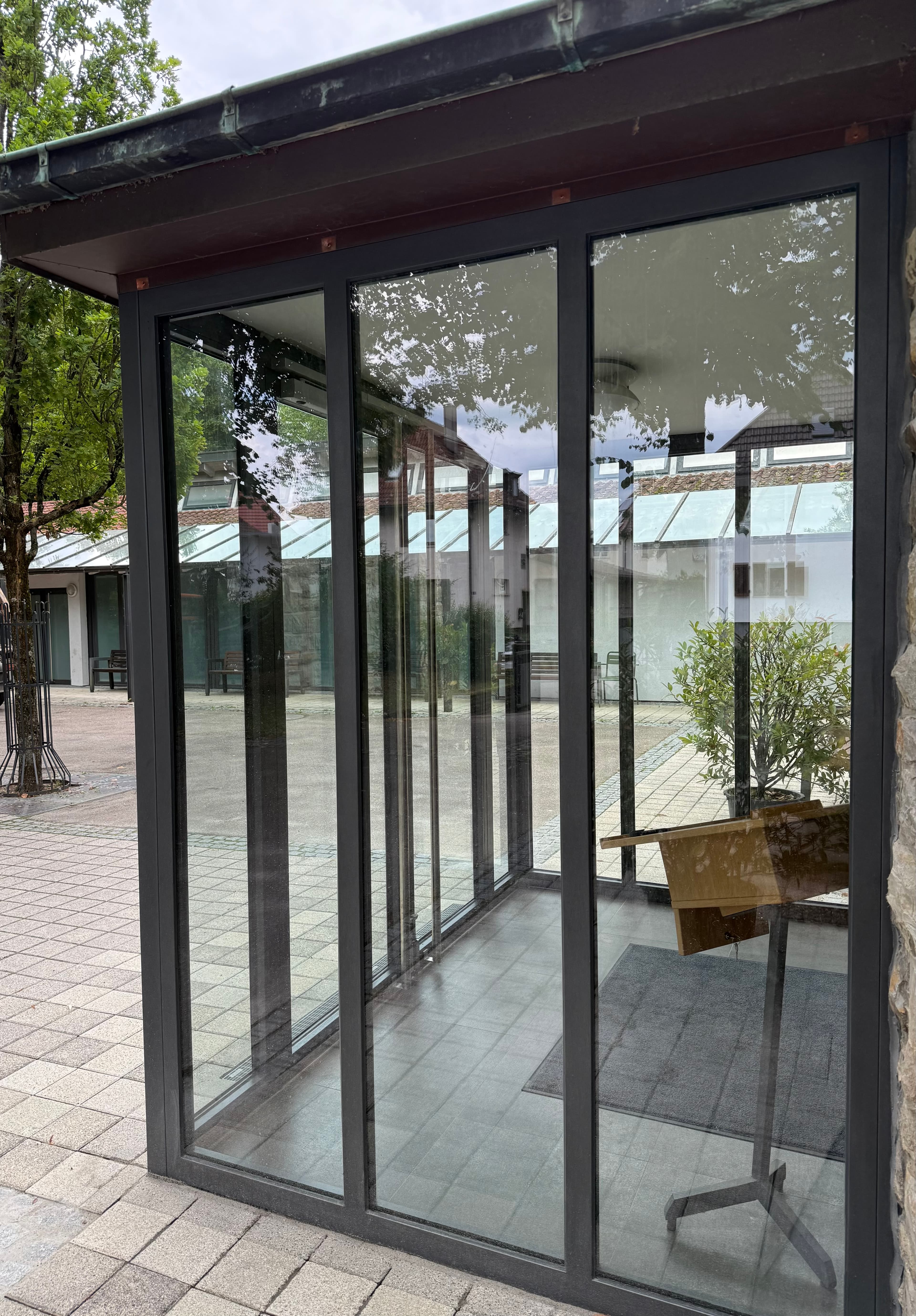 Moderner Windfang mit schlanken Metallprofilen an der Aussegnungshalle Neckarsulm